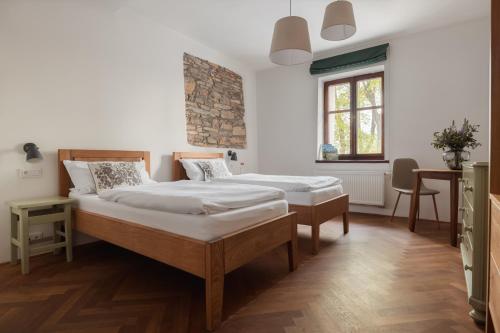 a bedroom with two beds and a table and a window at Vlaštovčí dům in Nové Město nad Metují
