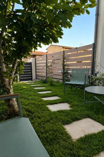 a garden with a bench and a table and a fence at Su Entu Suite Free Parking 5 min from the sea in Giba