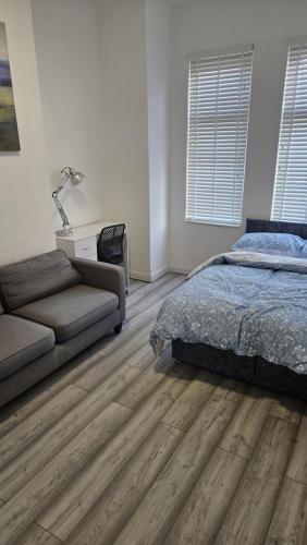 a bedroom with a bed and a couch at New Horizon Lodge in Leigh