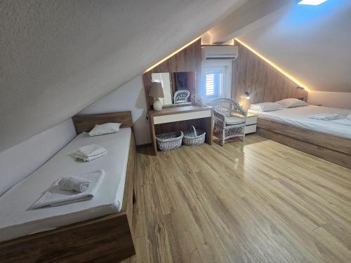 a attic bedroom with two beds and a desk at Nearby PORTONOVI-Norwegian-village DUPLEX in Đenovići
