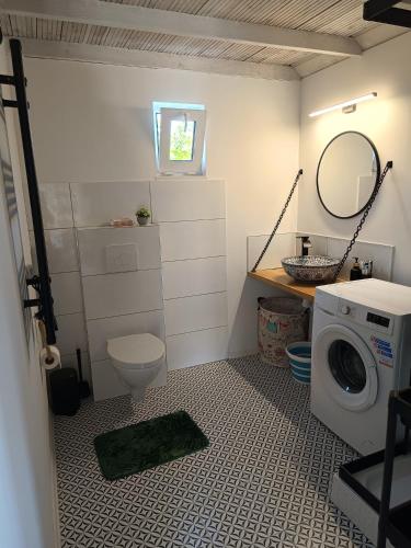 a bathroom with a toilet and a washing machine at Wilcza Polana Domki koło Międzygórza z jacuzzi i sauną in Jaworek