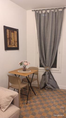 a table and chairs in a room with a window at T2 dans le centre historique de Manosque in Manosque