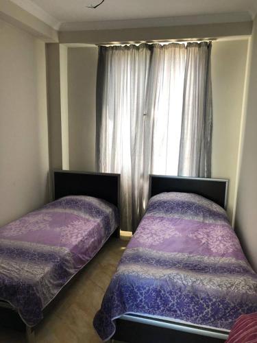 two beds sitting in a room with a window at Квартира in Ureki