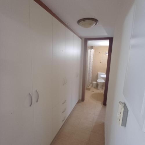 a hallway with white cabinets and a toilet in a bathroom at Guest House Mary in Porto Heli