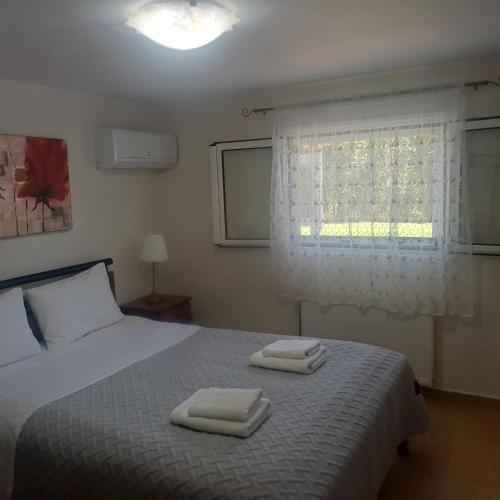 a bedroom with a bed with two towels on it at Guest House Mary in Porto Heli