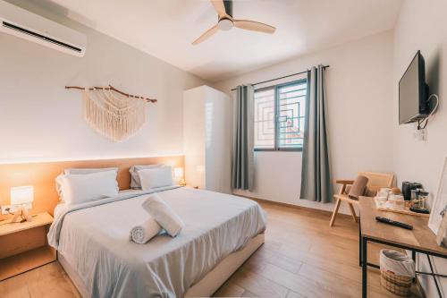 a white bedroom with a bed and a window at Casa Jardim di Sol in Praia