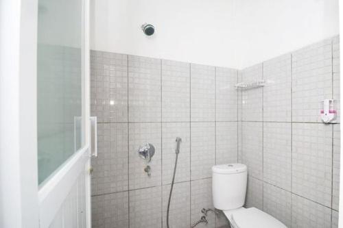 a bathroom with a toilet and a shower at RedDoorz Plus Syariah at Polamas Andalas in Padang