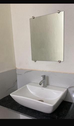 a white sink in a bathroom with a mirror at Rajyog Resort in Dhule