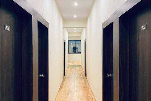 a hallway with two doors and a wooden floor at Rajyog Resort in Dhule