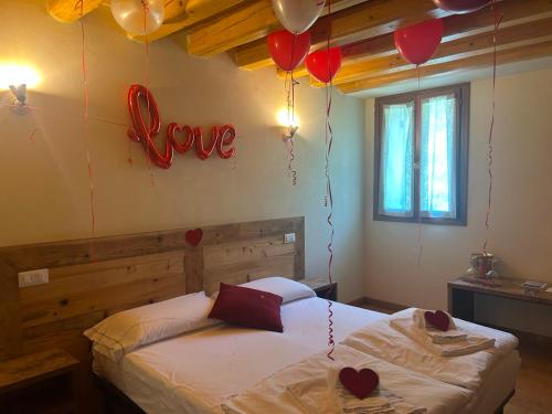 a bedroom with a bed with hearts on the wall and balloons at Asolo Norah's Hill Agri Rooms in Caenere