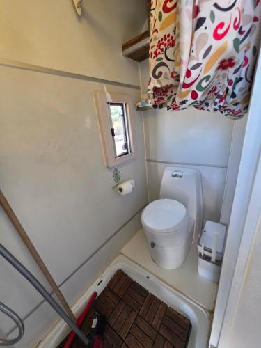 a small bathroom with a toilet and a window at רויאל וואן in Tiberias