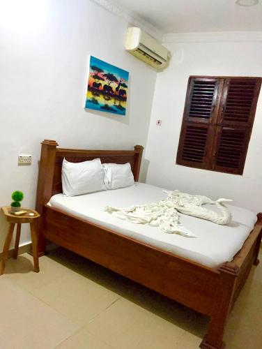 a bedroom with a bed with white sheets and a window at The courtyard Zanzibar in Ngambo
