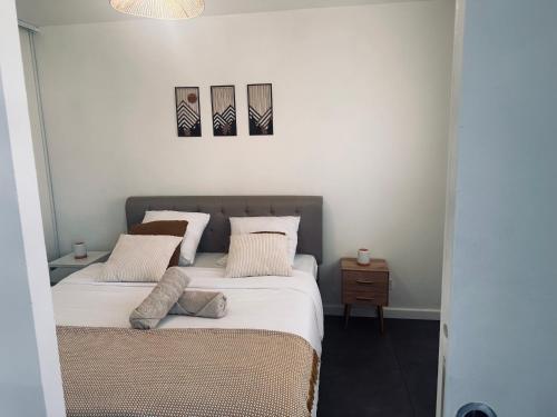 a bedroom with a bed and two paintings on the wall at La Pinéa 40 m2 T2 climatisation, tram E et parking in Saint-Égrève