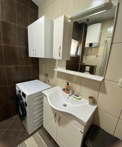 a bathroom with a white sink and a mirror at Purple Haze Apartments in Tivat