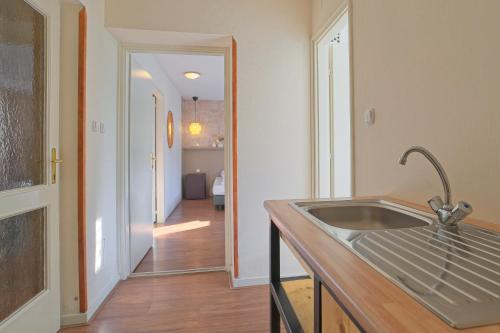 a kitchen with a sink and a hallway at Panzió-Kemping Bekölce in Bekölce