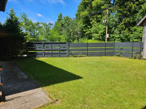 a fence in a yard with a green lawn at Casa Kavran in ŽeljezničkaStanica )) (( Skrad