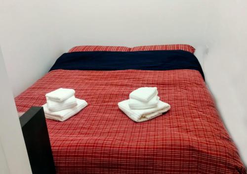 a bed with towels sitting on top of it at Cosy Open Space Apartment Bari in Bari