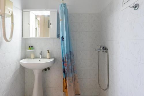 a bathroom with a shower and a sink at Synodinos Studios in Lixouri