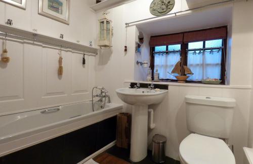 e bagno con lavandino, servizi igienici e vasca. di Ty Isaf a Dolbenmaen