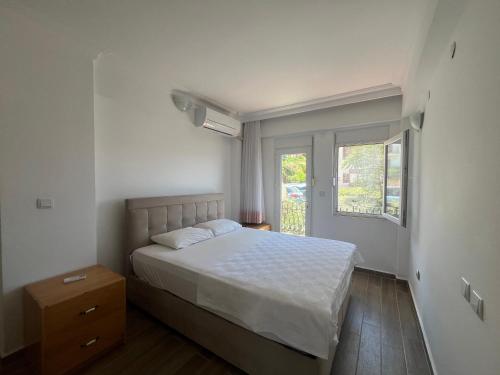 a bedroom with a white bed and a window at Heybe Apart in Kaş