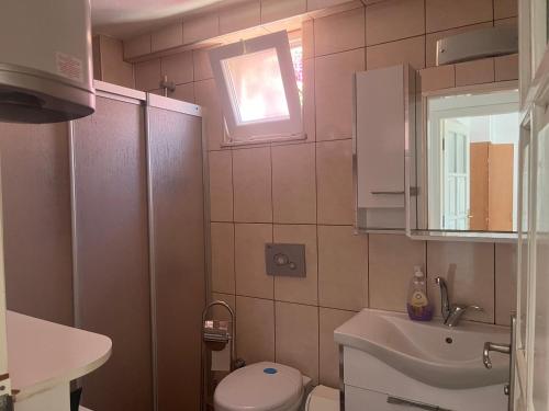 a small bathroom with a toilet and a sink at Heybe Apart in Kaş