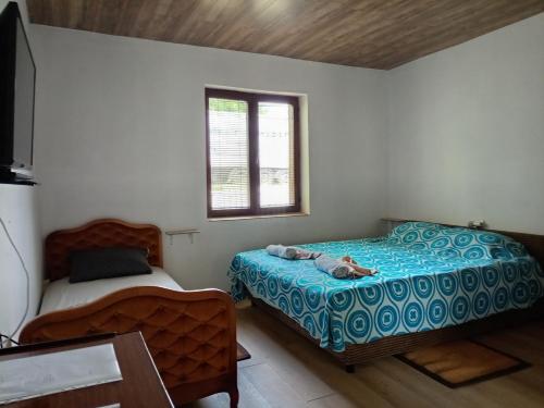 a bedroom with two beds and a window at Etno Han crvena reka in Bela Palanka