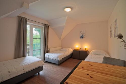 a bedroom with two beds and a window at Panzió-Kemping Bekölce in Bekölce
