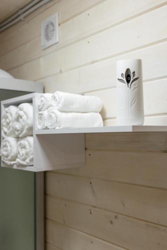 a shelf with towels and toilet paper on it at House Riverside in Kozmacz