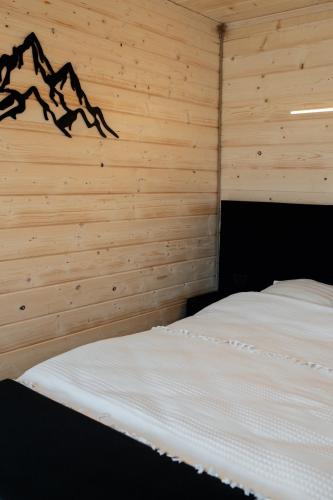 a bedroom with a bed in a wooden wall at House Riverside in Kozmacz