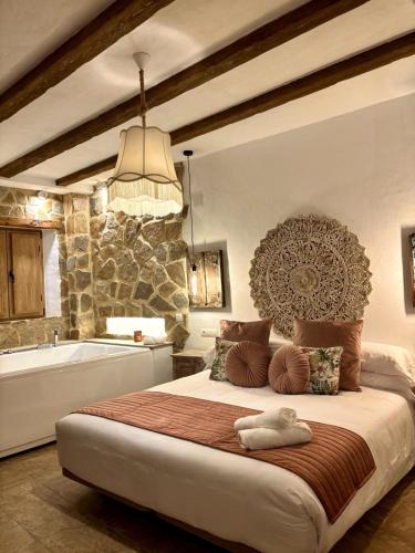 a bedroom with a large bed and a bath tub at Al Zahra Suites in Zahara de la Sierra