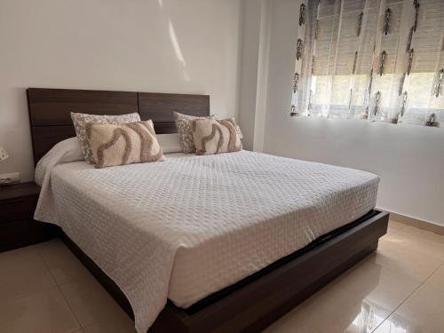 a bedroom with a large bed with white sheets and pillows at Benidorm Ambra in Villajoyosa