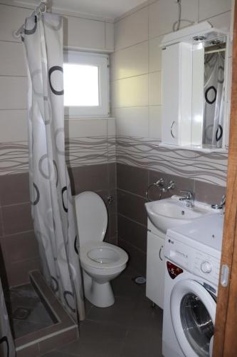 a bathroom with a toilet and a sink at Aurora Residence in Nalježići