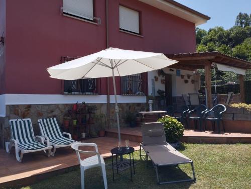 a patio with chairs and an umbrella in front of a house at Ca Blanca in Sorribas