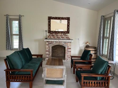a living room with three chairs and a fireplace at RajKamal's Farm in Borās
