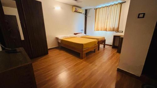 a room with two beds and a table in it at Hotel Royal Nest Inn in Coimbatore