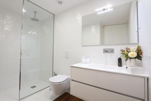 a bathroom with a toilet and a sink and a shower at Décimus Lodge - Premium Town Center Stay in Ponte de Lima