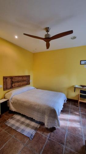 a bedroom with a bed and a ceiling fan at El Condado Casa Rural in Fuentes de Oñoro