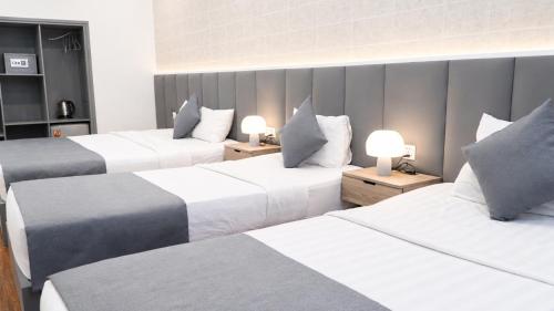 a hotel room with three beds and two lamps at Beauty House in Ho Chi Minh City