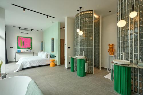 a bedroom with a bed and two green tables at Hotel Eden Ubud in Ubud