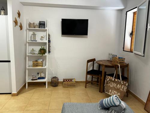 a living room with a table and a tv on a wall at Bella Javea in Jávea