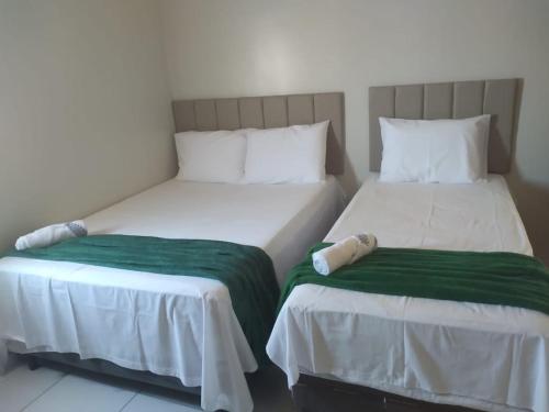 two beds sitting next to each other in a room at Hotel Paulista Sobradinho BA in Sobradinho - Bahia