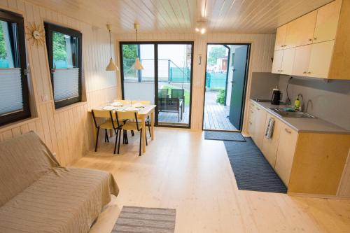 eine Küche und ein Esszimmer mit einem Tisch in einem winzigen Haus in der Unterkunft Domki KREDKA in Jastarnia
