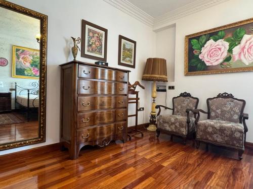 a room with a dresser and two chairs and a mirror at Al Centre Del Port in Cambrils