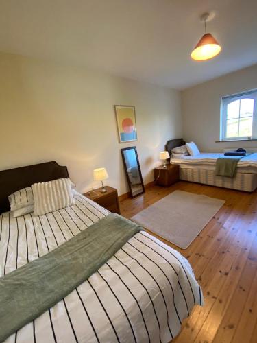 a large bedroom with two beds and a window at Atlantic Holiday Home in Milltown Malbay