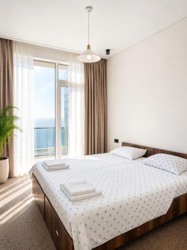a bedroom with a bed and a large window at Complex DEL MAR in Chakvi