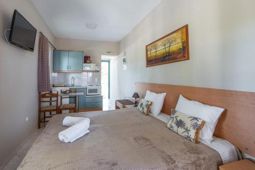 a bedroom with a bed and a small kitchen at Synodinos Studios in Lixouri