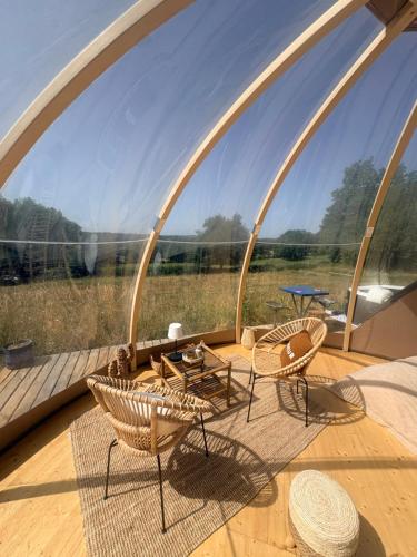a room with a large window with chairs and a table at La bulle de Clemence in Montfermy