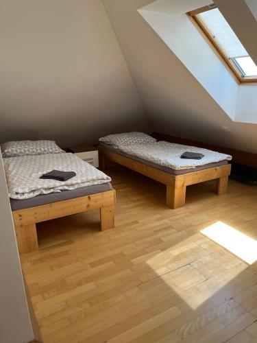 two beds in a room with a attic at Apartman Na Bubnu in Náchod