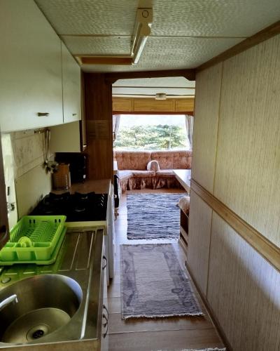 a kitchen with a sink and a view of a room at Domek Samanta in Grzybina