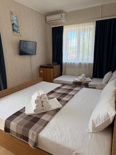 a hotel room with two beds with towels on them at Otel delfin in Karolino-Buhaz